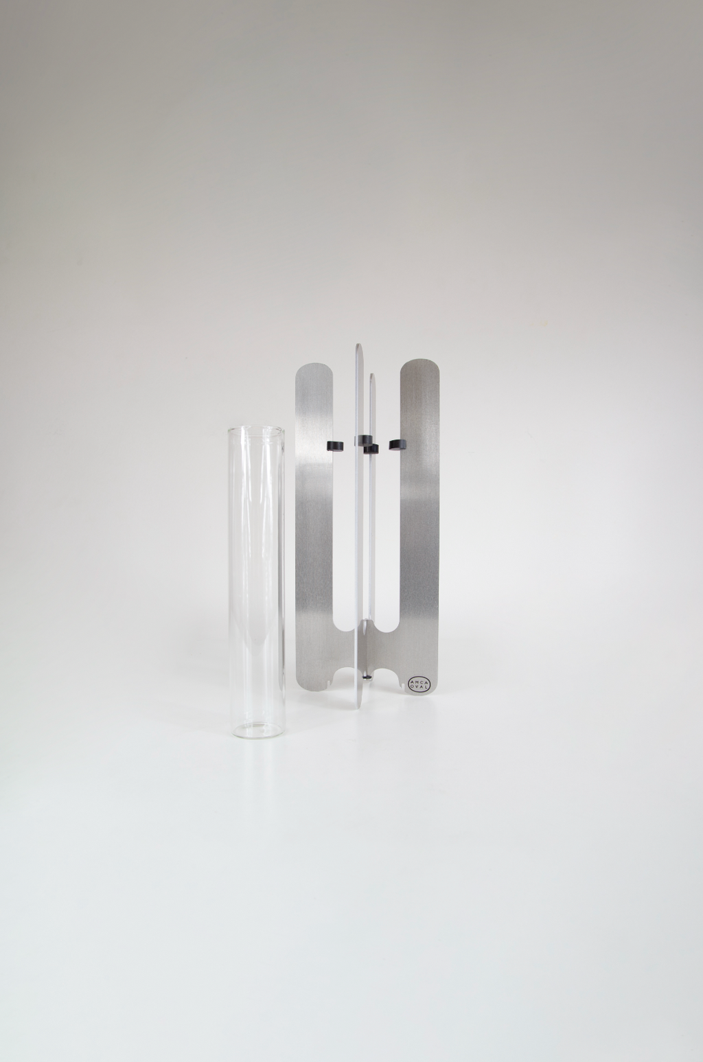Modern flower vase by AMCA Oval — minimalist design, sculptural aluminium base, transparent glass tube, collectible home decor.