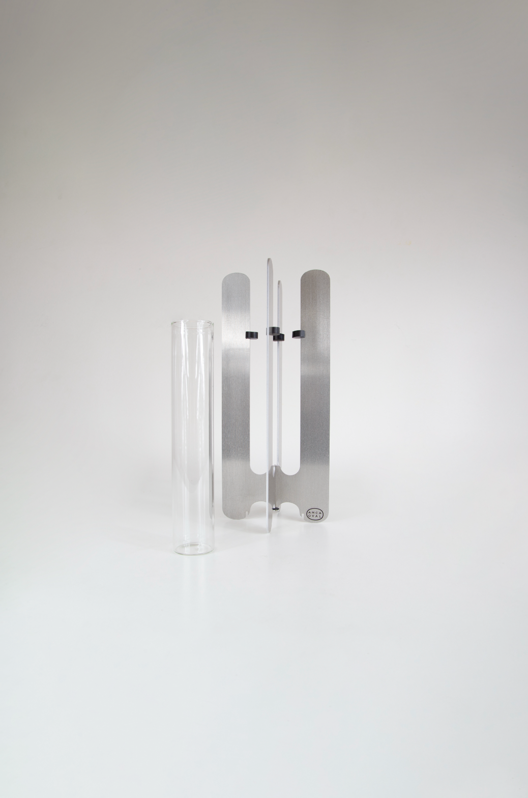 Modern flower vase by AMCA Oval — minimalist design, sculptural aluminium base, transparent glass tube, collectible home decor.