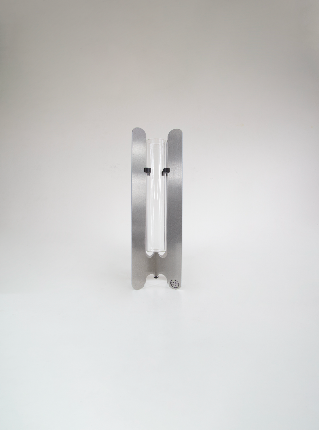 Modern flower vase by AMCA Oval — minimalist design, sculptural aluminium base, transparent glass tube, collectible home decor.