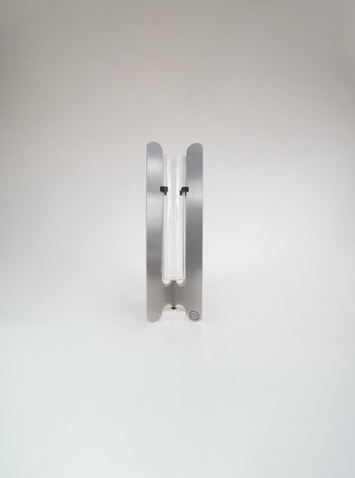 Modern flower vase by AMCA Oval — minimalist design, sculptural aluminium base, transparent glass tube, collectible home decor.